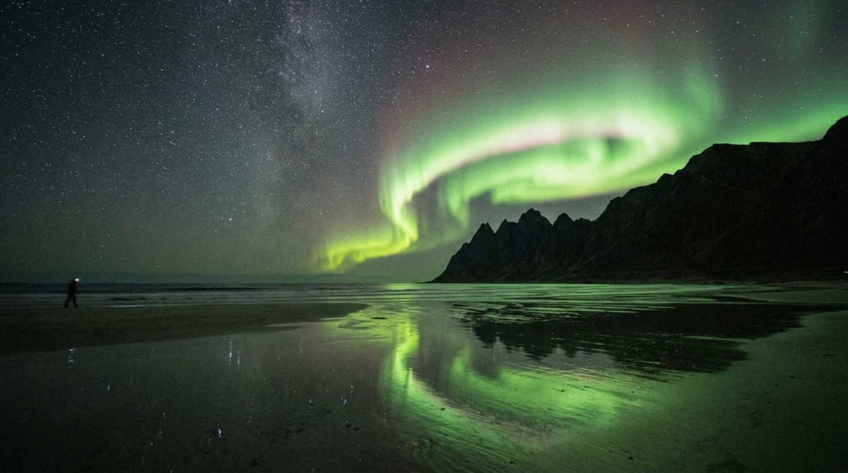 Northern lights reflected in wet sand at Skagsanden beach, one of the best places to see the Lofoten northern lights